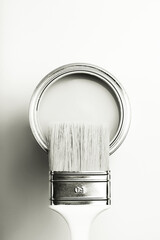 Fototapeta na wymiar Paintbrush resting on an open white paint can, presenting a high key, monochrome minimalist composition. Color of 2026 year dancer in the white cloud