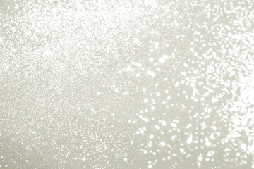 White silver glitter dust sparkling creating an abstract background texture with bright light bokeh, ideal for festive celebrations. Color of 2026 year dancer in the white cloud