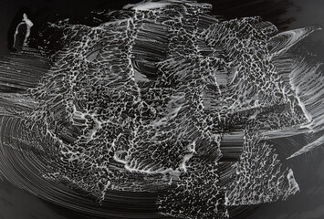 White soap scum and streaks on a black glossy surface.