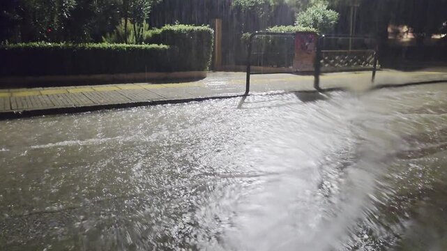 Storm Byron in Athens Greece, shot through car window blurred by falling water. Heavy rain causes flooding on streets. Water accumulates rapidly, affecting visibility and car traffic conditions.