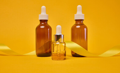 Various glass bottles with pipettes containing cosmetic serums or oils.