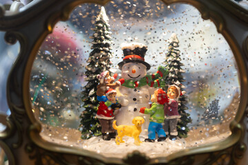 Christmas snow globe with snowman and children