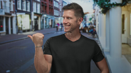 Fototapeta premium Man showing thumbs up with his right hand on a busy city street lined with shops and pedestrians; approval casual.