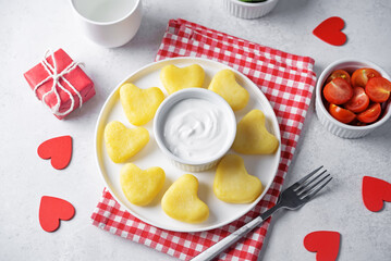 Potato gnocchi in the form of hearts with cream sauce for Valentine's day holidays on a white background