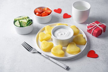 Potato gnocchi in the form of hearts with cream sauce for Valentine's day holidays on a white background