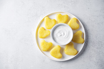 Potato gnocchi in the form of hearts with cream sauce for Valentine's day holidays on a white background