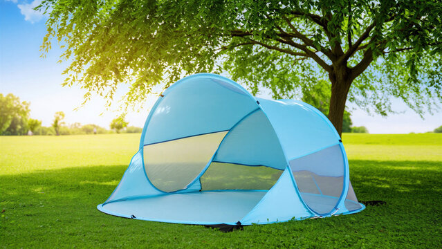 Blue pop-up beach cabana on green grass in sunny park, portable UPF sun shelter for summer relaxation, lightweight and easy setup tent, outdoor leisure, coastal-inspired shade for sunny day