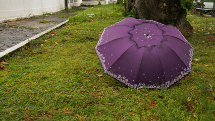 Concept of loneliness, abandonment, sadness, an abandoned umbrella in a garden