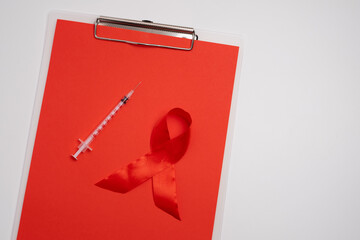  Red ribbon and syringe symbol. Global health awareness.