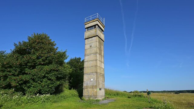 Wachturm der ehemaligen Innerdeutsche Grenze unter wolkenlosem Himmel neben gr&uuml;n bewachsener Fl&auml;che, Sommer, Fladungen, Frankenheim, Hohe Rh&ouml;n, Rh&ouml;n, Hessen, Th&uuml;ringen, Bayern, Deutschland, Europa