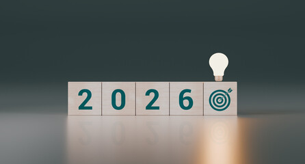 Wooden cubes with the text 2026, plus an arrow, a target, and a spotlight. Concept of new ideas for personal goals, annual planning, and resolutions to improve life. 3D rendering.