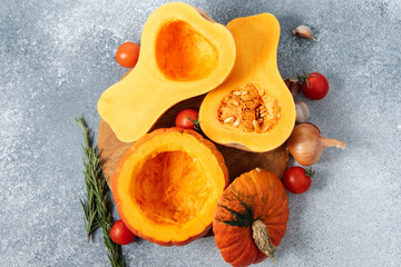 Fresh squash and tomatoes on a cutting board with herbs and garlic in a kitchen setting, cleaned of seeds