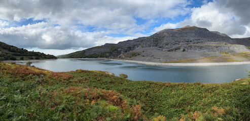 Panorama of broken cloud casting shadows across Llyn Peris and the slate quarry