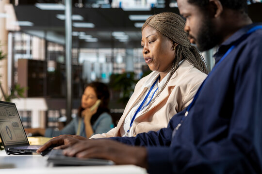 Young employee and manager gathered at the desk to examine data on pc, discussing objectives and strategizing solutions to solve administrative tasks. Aligning business goals and milestones. - Powered by Adobe