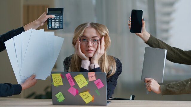 Stressed business woman in office female hands giving phone notebook papers calculator from sides multitasking frustrated businesswoman girl holding head feeling pressure overload overworked burnout