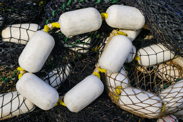 Black industrial fishing net and white floats in closeup forming flowing pattern