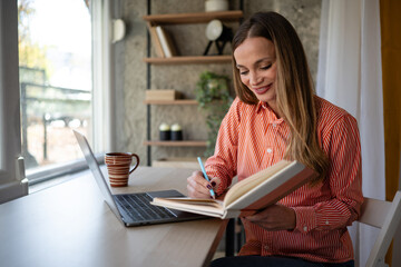 Obraz premium Woman writing notes working from home office