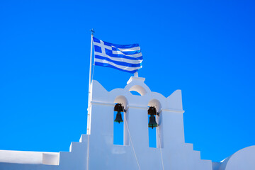 Church with two bells and the Greece flag in Folegandros