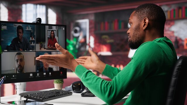Remote worker looking at PC monitor discussing with coworkers during videocall from home. Computer display used by teleworker in remote teleconference meeting with colleagues. Camera A.