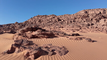 Fototapeta premium A trip to Sahara desert in Algeria. Beautiful african travel photo. Sandy landscapes, mountains, rocks, dunes, and nature. Summer vacation in arab country.