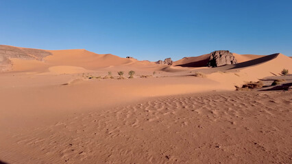 A trip to Sahara desert in Algeria. Beautiful 
african travel photo. Sandy landscapes, mountains, rocks,
dunes, and nature. Summer vacation in arab country.