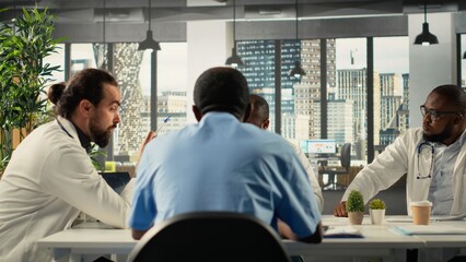 Health specialists and medics collaborating in conference room. Healthcare staff brainstorming treatment ideas and wellness through teamwork and communication in boardroom.