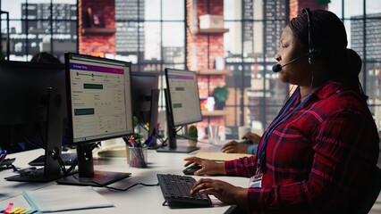Call center agent listening to customer needs, providing step by step guidance. Customer center worker manages incoming and outgoing calls, walking clients through technical solutions, camera B