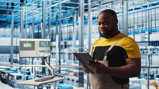 Photovoltaics smart factory specialist analyzing data using tablet. African american man in industry 4.0 solar panels plant producing renewable energy using notebook to review system metrics, camera A - Powered by Adobe