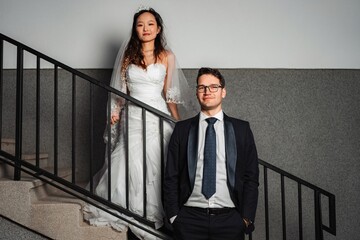 Interracial wedding couple posing on a staircase