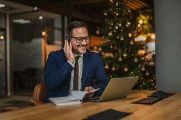 Businessman teleworking having a cheerful video call during christmas