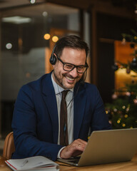 Businessman teleworking having a cheerful video call during christmas
