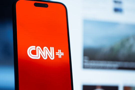 Usinsk, Russian Federation - December 04, 2025: Smartphone displaying CNN+ logo on vibrant red background, showcasing modern media technology and digital streaming services with copy space