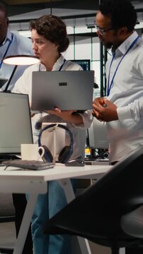 Vertical video Engineering team working together in office, using specialized hardware to accelerate complex AI calculations. Coworkers cooperating, managing systems for machine learning training