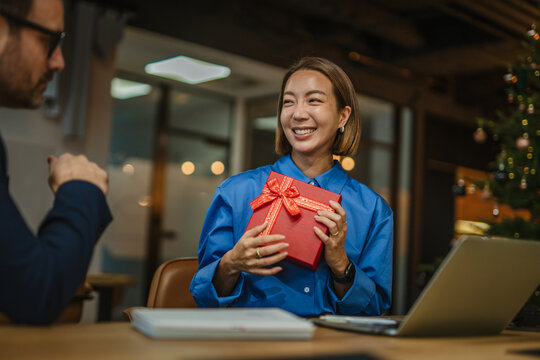 Woman receiving christmas gift at office celebration