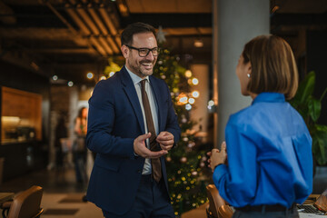 Fototapeta premium Business colleagues networking and discussing work at office christmas party