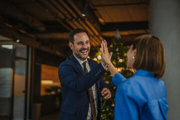 Business colleagues high five celebrating success in office