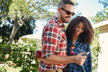 Couple, online and people with smartphone, backyard or review photos on social media app and embrace. Outdoor, man and woman with mobile for pictures, scroll and interracial relationship at house