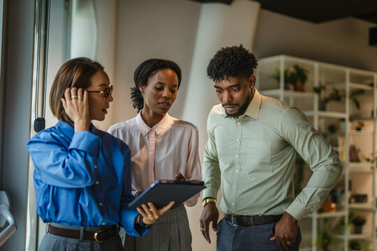 Diverse business team collaborating with digital tablet in office
