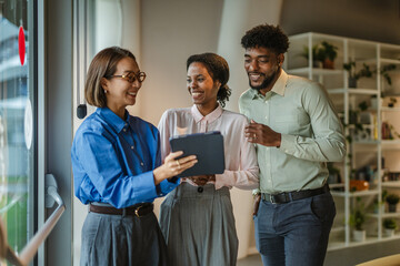Diverse business team collaborating with digital tablet in office