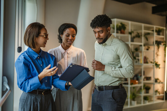Diverse business team collaborating with digital tablet in office