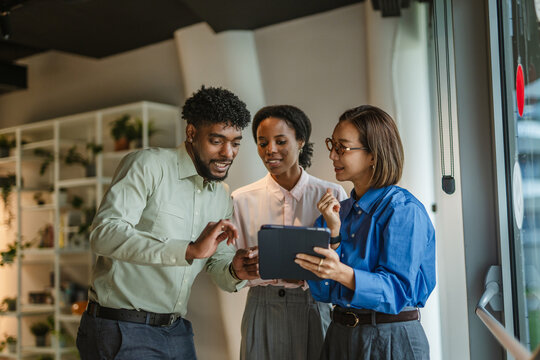 Diverse business team collaborating with digital tablet in office