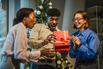 Coworkers exchanging gift during office christmas celebration