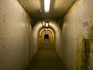 夜の細く暗いトンネルで先が暗闇のイメージ