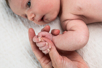 Newborn baby hand gripping parent finger showing love connection