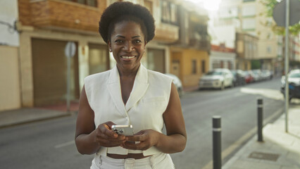 Woman texting on smartphone, hands visible holding device, wearing white sleeveless vest and...