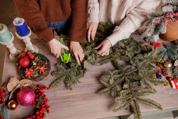 Women Cutting Fir Branches for Handmade Christmas Decorations at Home