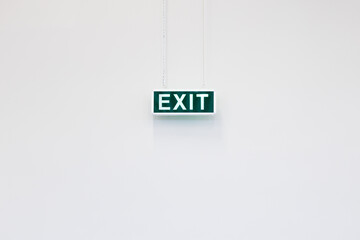 Emergency exit sign isolated on white minimalist wall. Clean and simple emergency exit sign on neutral background, ideal for safety, architecture and instruction concepts.