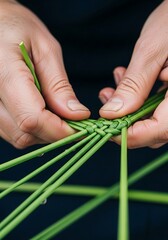 Hands carefully weaving intricate pattern with fresh green plant stems
