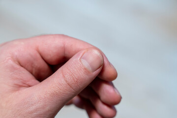 Close-up view of a human hand, fingers interlocked in a relaxed position, showcasing skin texture and details. Suitable for concepts relating to touch, interaction, and manual labor.