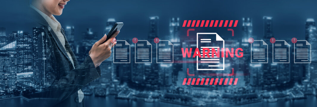 A businesswoman engages with her smartphone while a digital security warning is highlighted over a city skyline, illustrating the importance of cybersecurity in modern life. Gantry